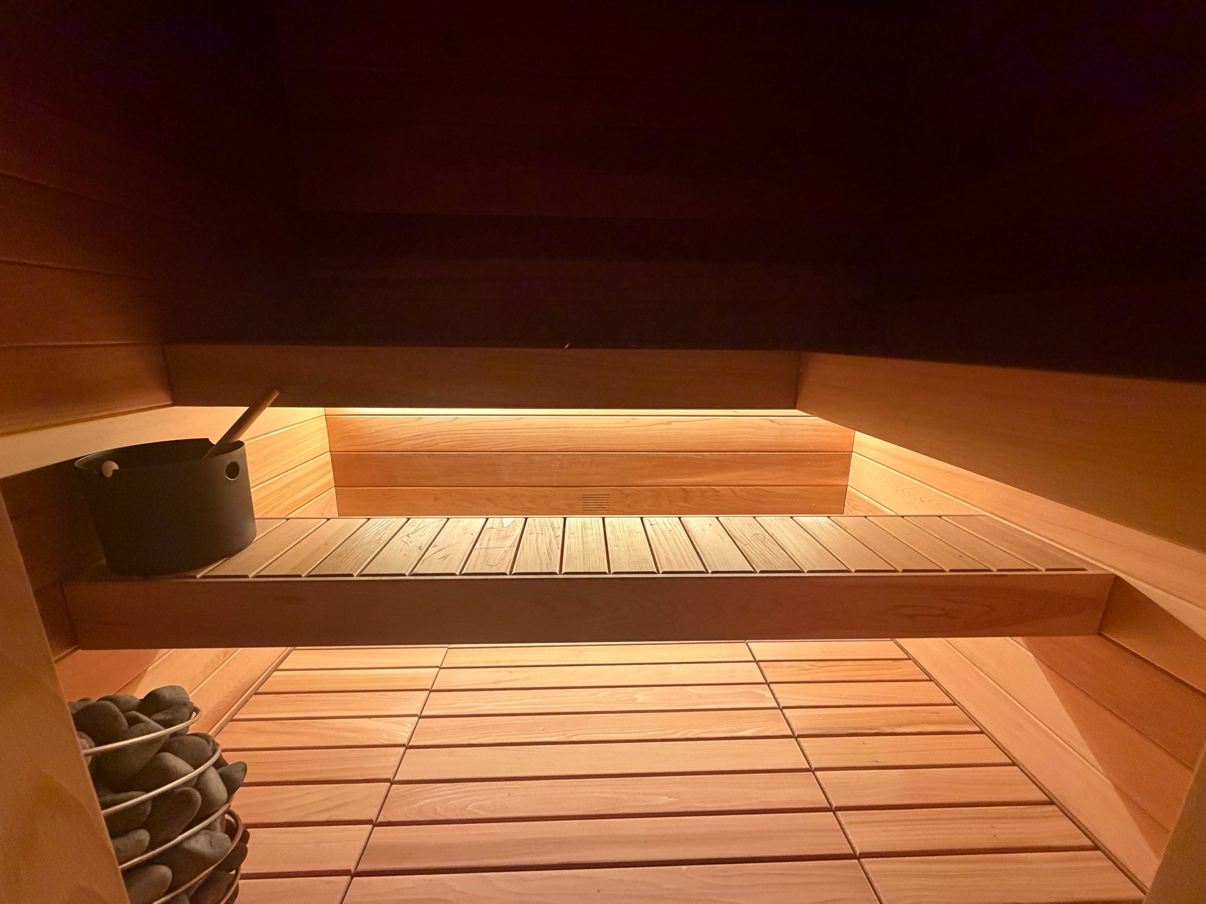 The Tiiviis bench lit from beneath, with cedar walls and floor